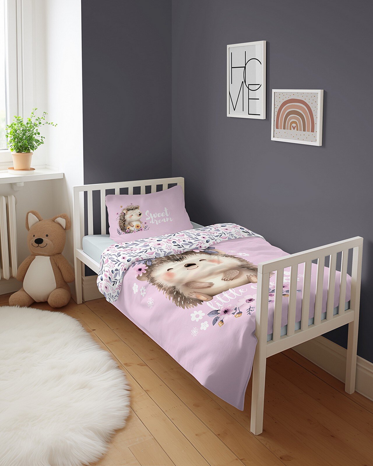 Pokój dziecięcy z łóżkiem, na którym znajduje się pościel z motywem jeża i napisem \'Sweet Dreams\'. Na ścianie wiszą dwa obrazy, jeden z napisem \'HOME\', drugi z tęczowym wzorem.