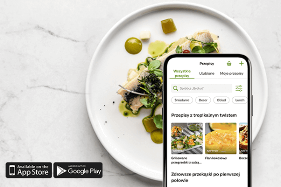 Na marmurowym tle znajduje się talerz z elegancko podanym daniem oraz smartfon z aplikacją przepisów kulinarnych. Na dole widoczne są ikony \'Available on the App Store\' i \'Android App on Google Play\'.