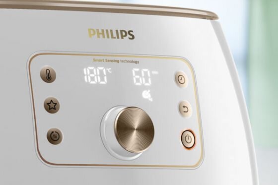 Panel sterowania frytkownicy z wyświetlaczem pokazującym temperaturę 180°C i czas 60 minut. Widoczne są przyciski funkcyjne oraz logo PHILIPS.