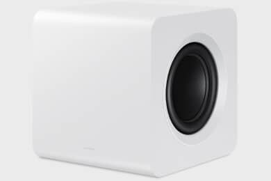 Biały subwoofer o zaokrąglonych krawędziach z widocznym czarnym głośnikiem na jednej ze ścianek. Na dolnej krawędzi znajduje się subtelne logo producenta.