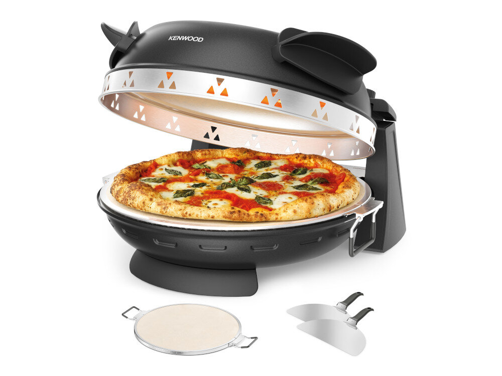 Czarny piec do pizzy z otwartą pokrywą, w środku znajduje się pizza z serem i bazylią. Obok pieca leżą kamień do pieczenia i łopatka do pizzy.