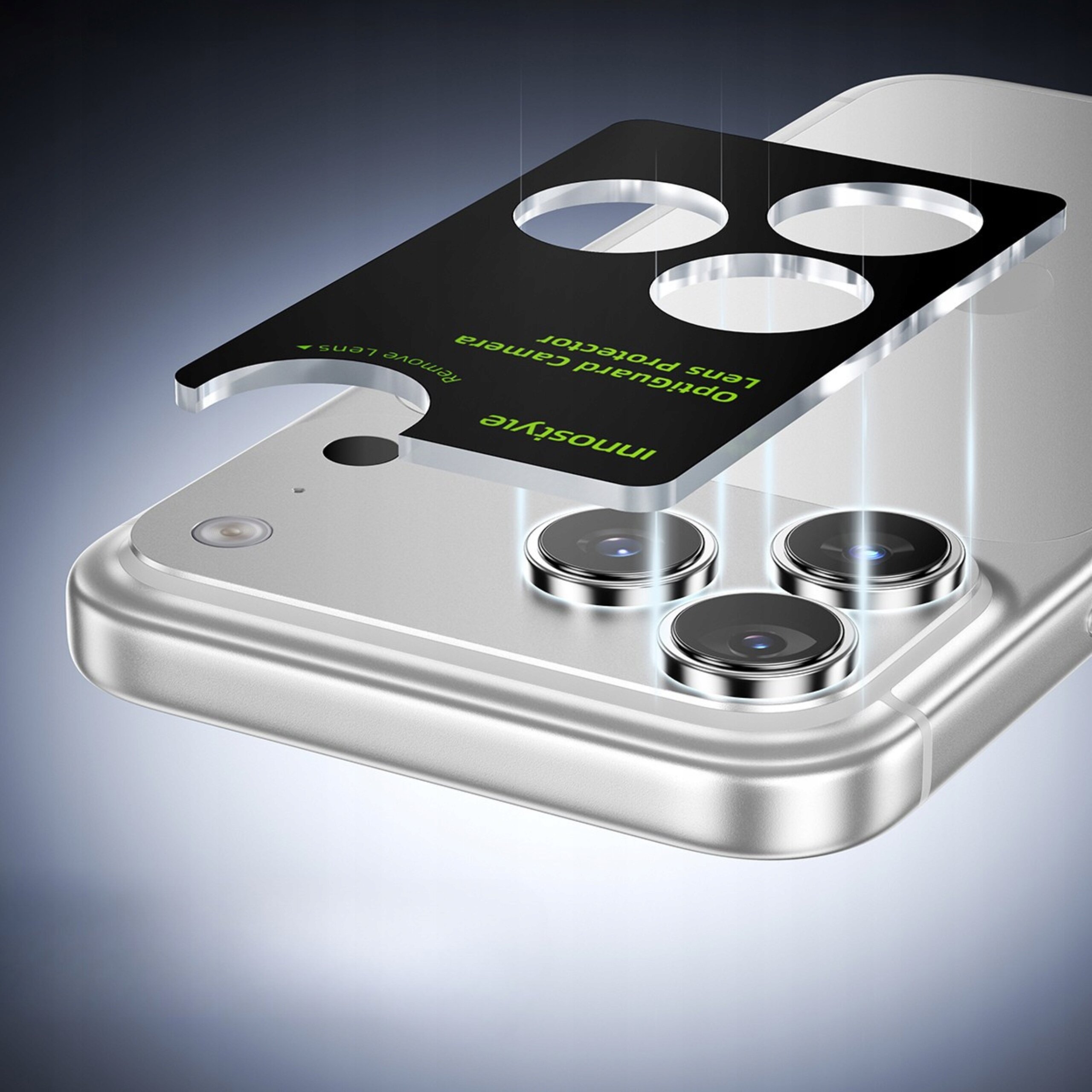 Obraz przedstawia srebrny telefon z trzema obiektywami aparatu, nad którym unosi się czarna osłona z wycięciami na obiektywy i zielonym napisem \'innostyle Opgurad Camera Lens Protector\'.