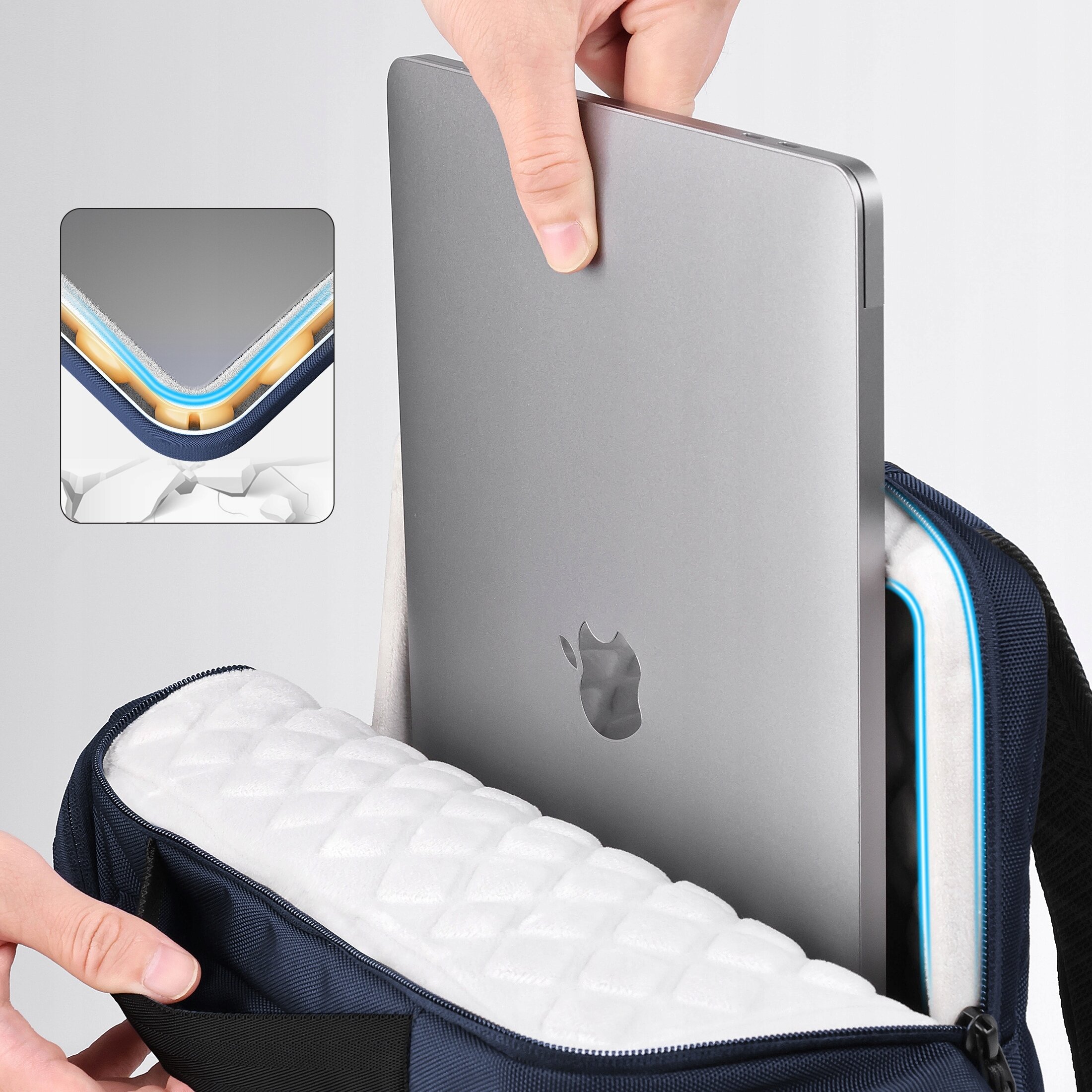 Osoba wkłada srebrny laptop do plecaka z białym, pikowanym wnętrzem. Na laptopie widoczne jest logo w kształcie nadgryzionego jabłka.