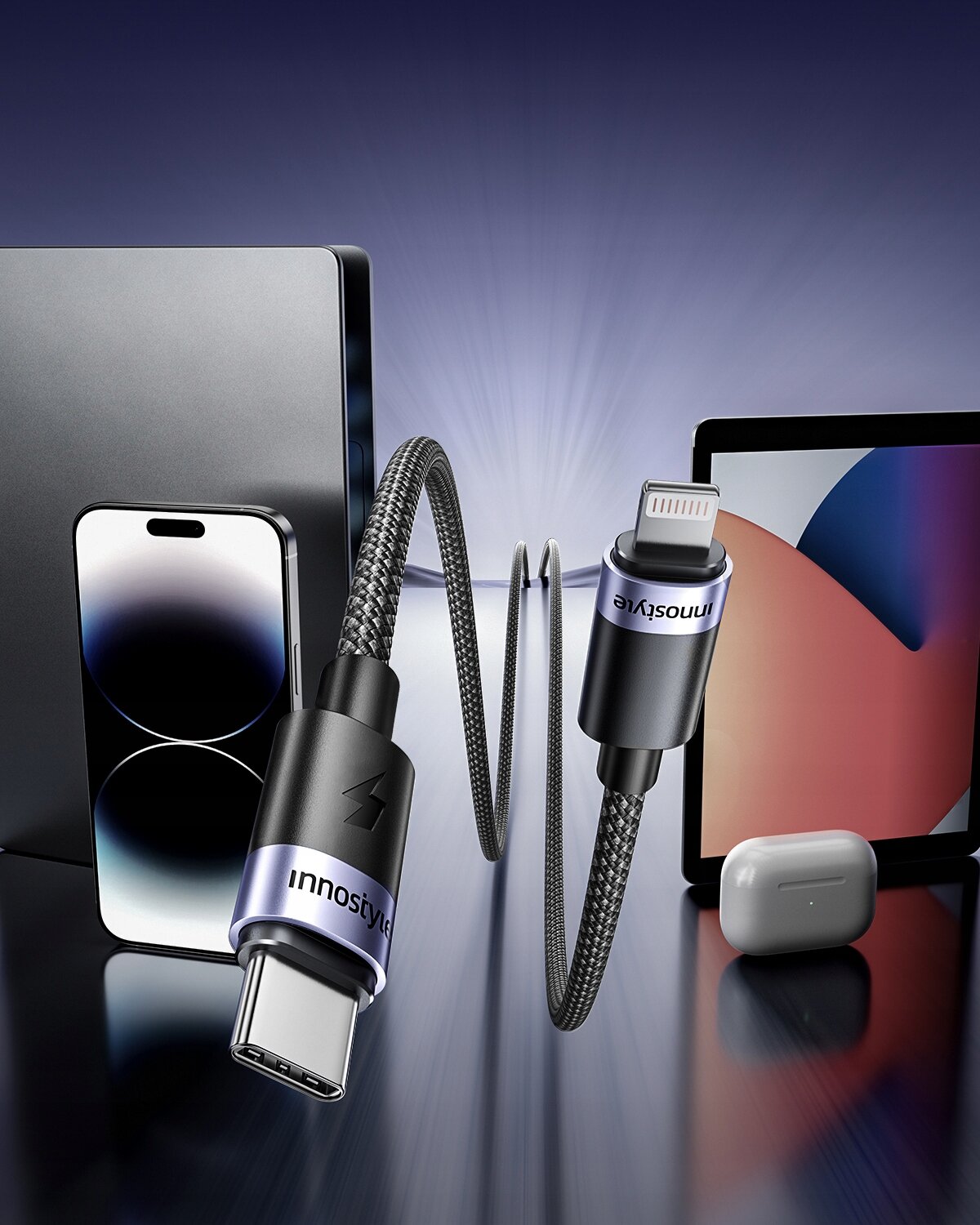 Na zdjęciu widoczna jest ładowarka z kablem USB-C do Lightning marki Innostyle, otoczona przez smartfon, tablet i etui na słuchawki. Na kablu widoczny jest napis \'Innostyle\'.