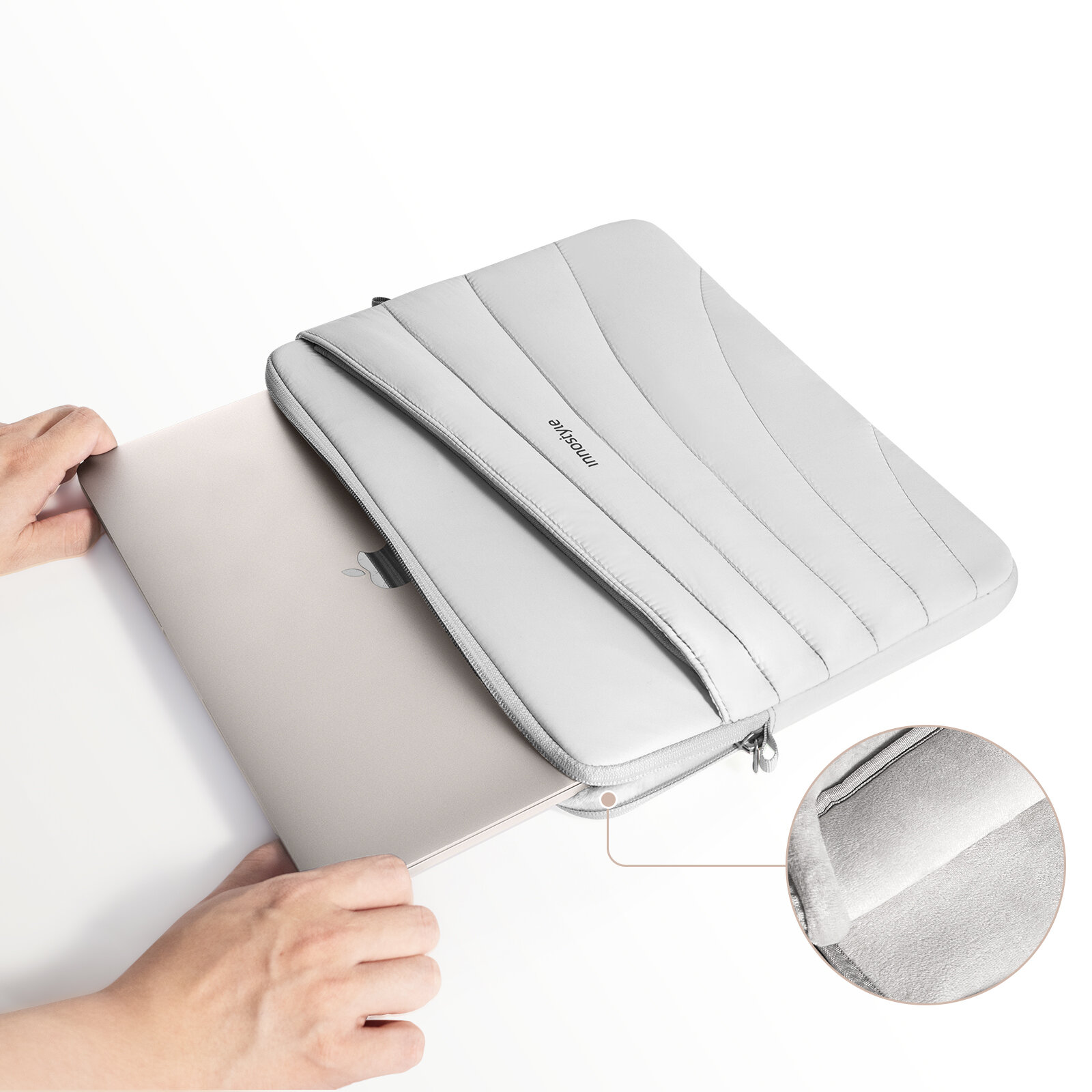 Szara torba na laptopa z napisem \'Innostyle\' na wierzchu, z widocznym laptopem wkładanym do środka oraz powiększonym fragmentem wnętrza torby pokazującym miękką wyściółkę.