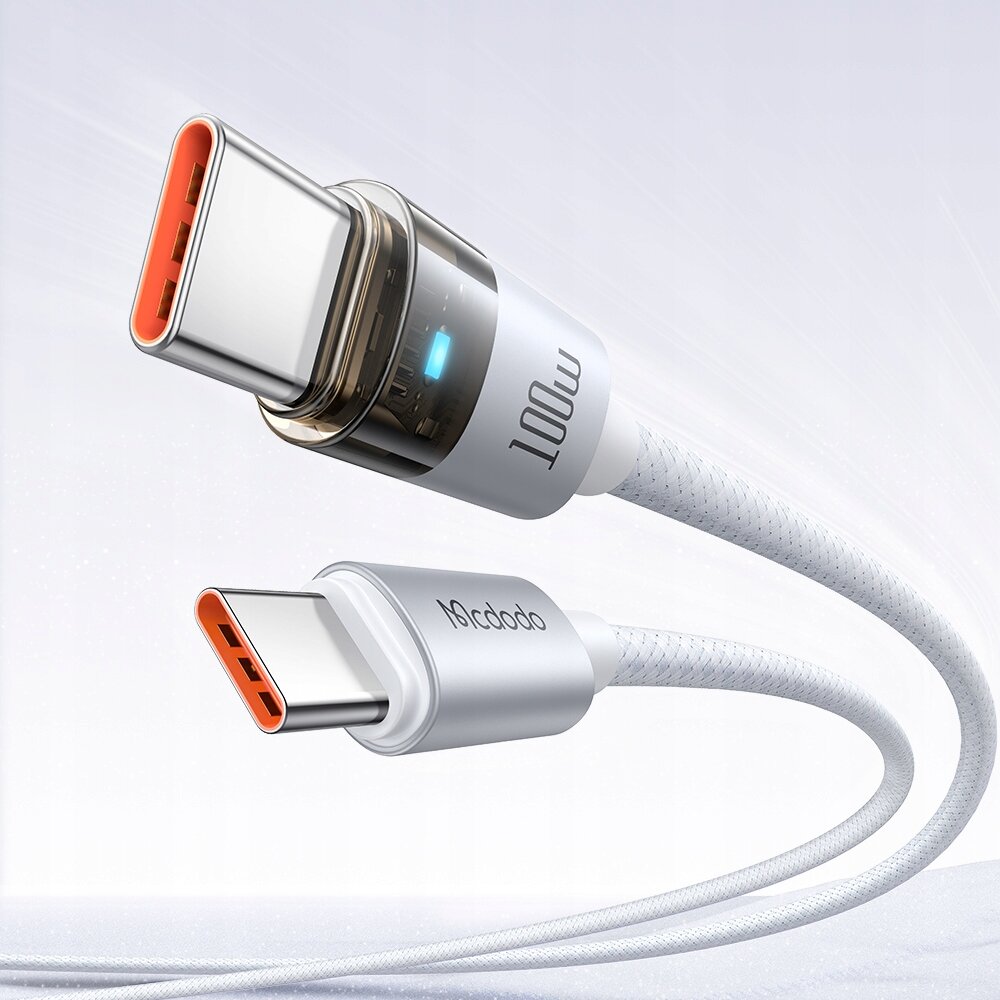 Na zdjęciu widoczny jest biały kabel USB-C z metalowymi końcówkami, na których znajdują się napisy \'100W\' i \'Mcdodo\'. Kabel ma plecioną strukturę, a w tle znajduje się jednolite, jasne tło.