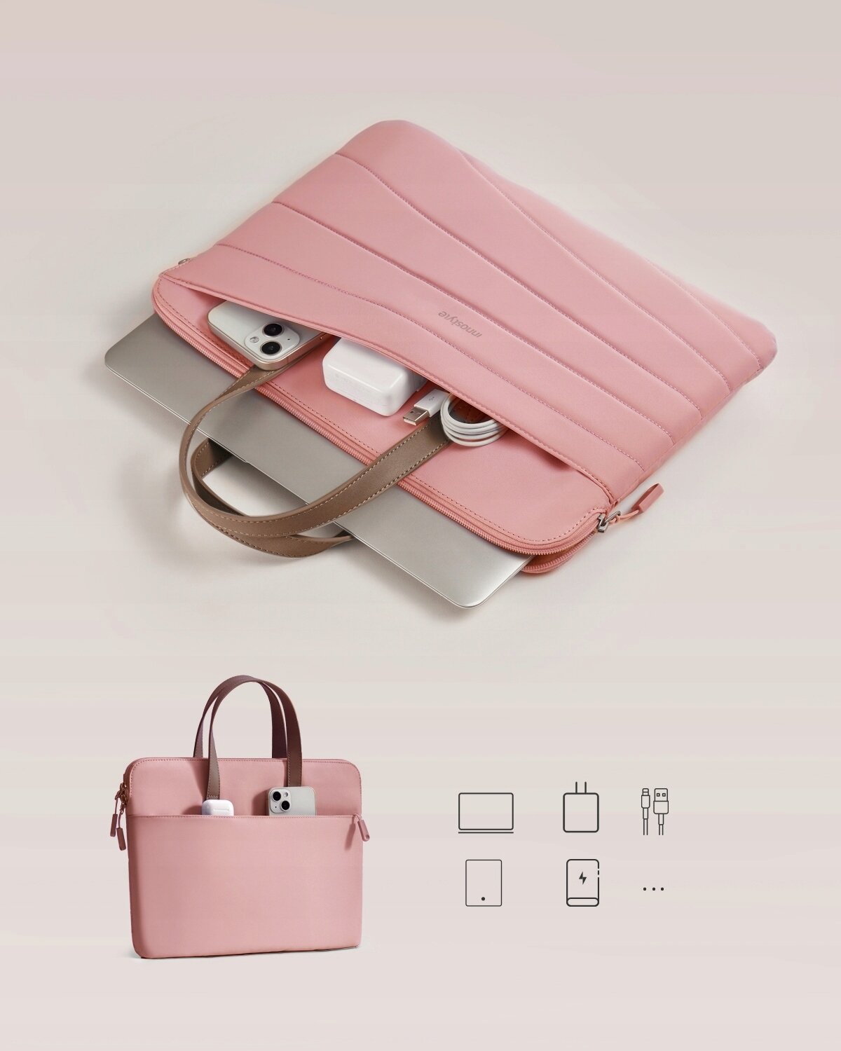 Różowa torba na laptopa z brązowymi uchwytami, zawierająca laptop, telefon, ładowarkę i kabel. Na torbie widoczny jest napis \'by Carrylite\'.