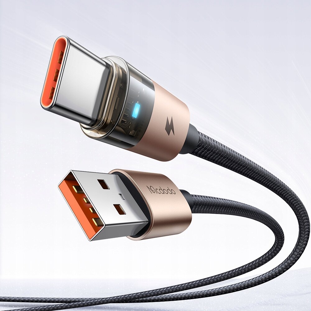 Złoty kabel USB-A do USB-C z plecionym przewodem i oznaczeniem \'Mcdodo\' na złączu. Widoczny jest również symbol błyskawicy oraz niebieska dioda LED na złączu USB-C.