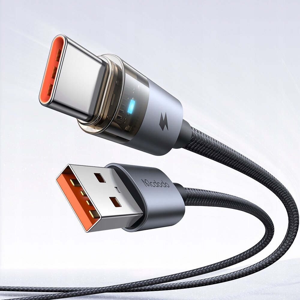 Zdjęcie przedstawia czarny kabel USB-A do USB-C z metalowymi końcówkami, na jednej z nich widoczny jest niebieski wskaźnik LED. Na obudowie wtyczki USB-A znajduje się napis \'Mcdodo\'.