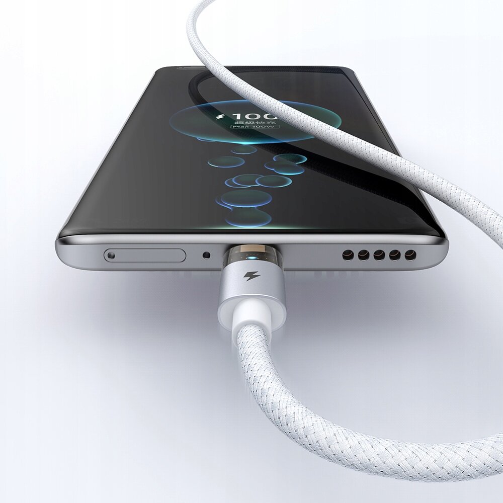 Na obrazie widać smartfon z podłączonym białym kablem USB-C, który ma plecioną osłonę. Na ekranie telefonu wyświetla się symbol ładowania z napisem \'100%\'.