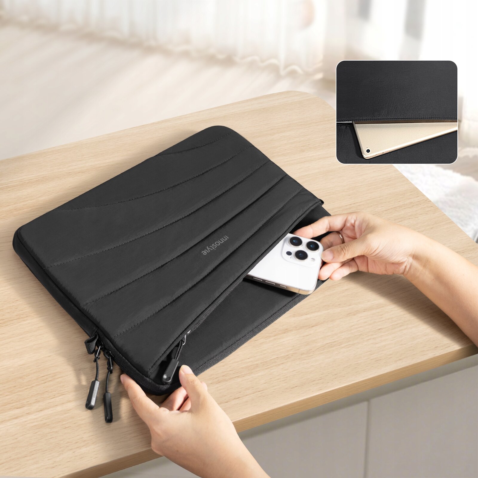 Czarna torba na laptopa z napisem \'innostyle\' na środku, leży na drewnianym stole, a obok niej znajduje się telefon. W prawym górnym rogu widoczny jest zbliżony widok torby z laptopem w środku.
