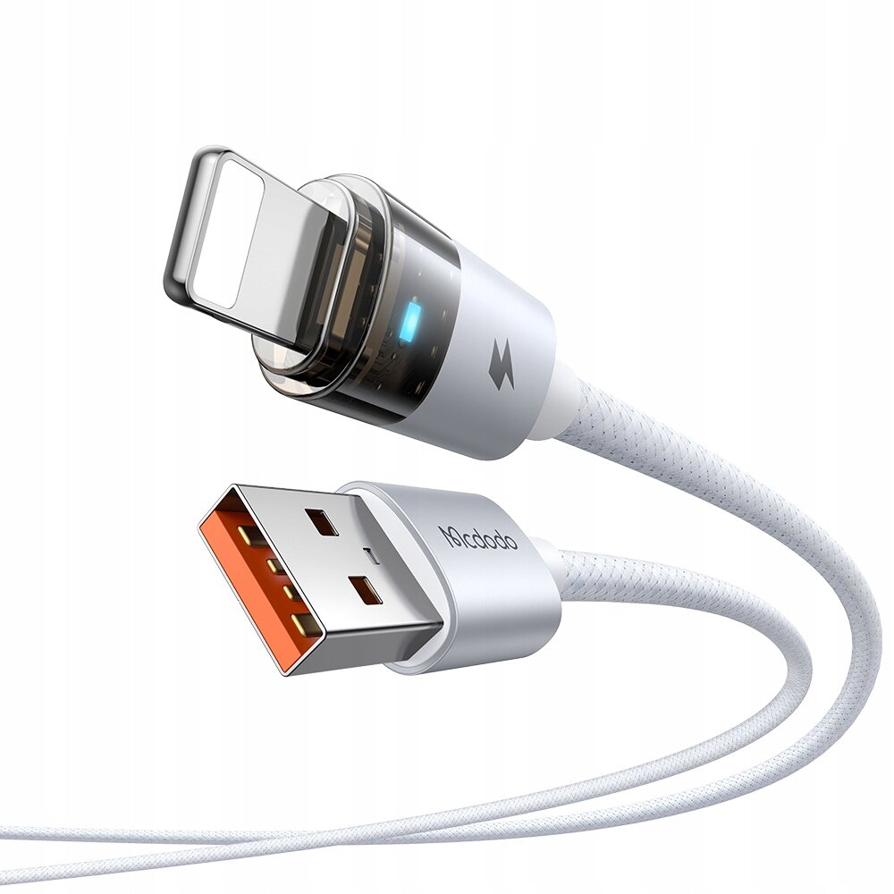 Na obrazie widoczny jest biały kabel USB z końcówką Lightning oraz USB, z logo \'Mcdodo\' na wtyczce. Kabel posiada metaliczne wykończenia i widoczny jest niebieski wskaźnik LED.