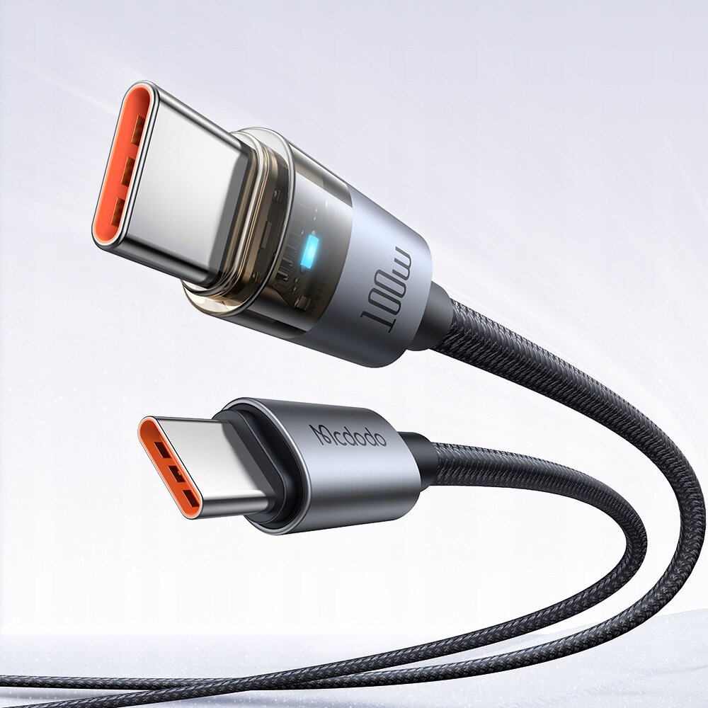 Zdjęcie przedstawia dwa złącza kabla USB-C z metalowymi końcówkami i plecionym przewodem, z widocznymi napisami \'100W\' i \'Mcdodo\'. Tło jest jasne i neutralne.