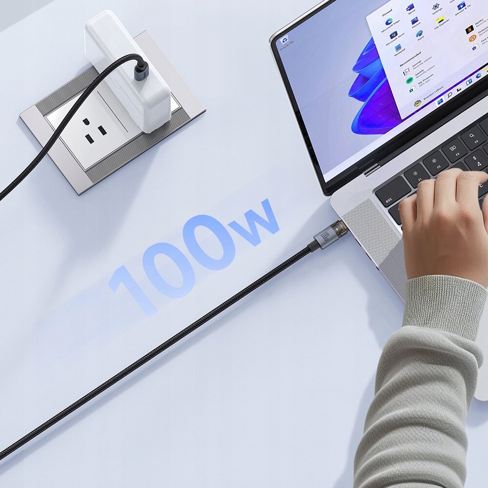 Zdjęcie przedstawia kabel USB-C podłączony do laptopa i gniazdka elektrycznego, z widocznym napisem \'100w\' na tle. Na ekranie laptopa widoczne są ikony aplikacji.