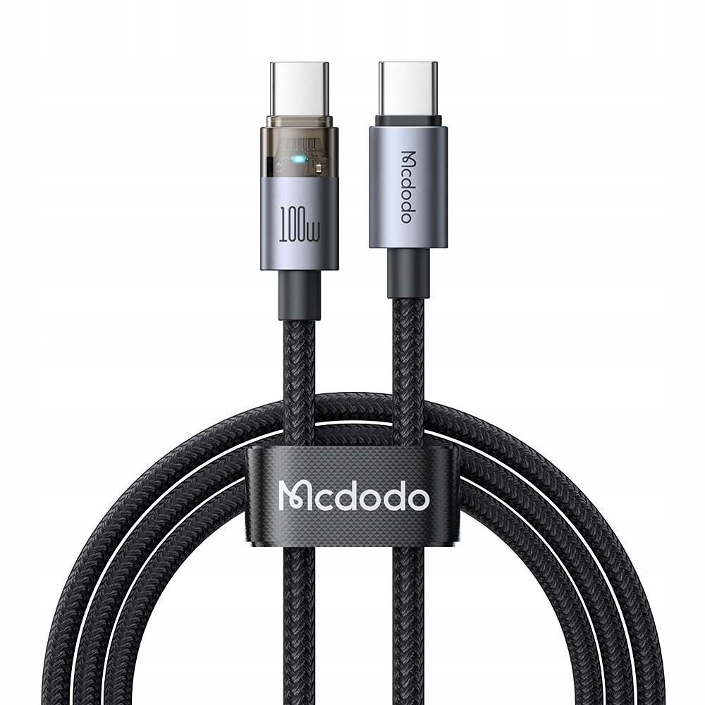 Na obrazie widoczny jest czarny kabel USB-C z plecionym oplotem, zakończony dwoma wtyczkami USB-C. Na jednej z wtyczek znajduje się napis \'100W\', a na drugiej \'Mcdodo\'.
