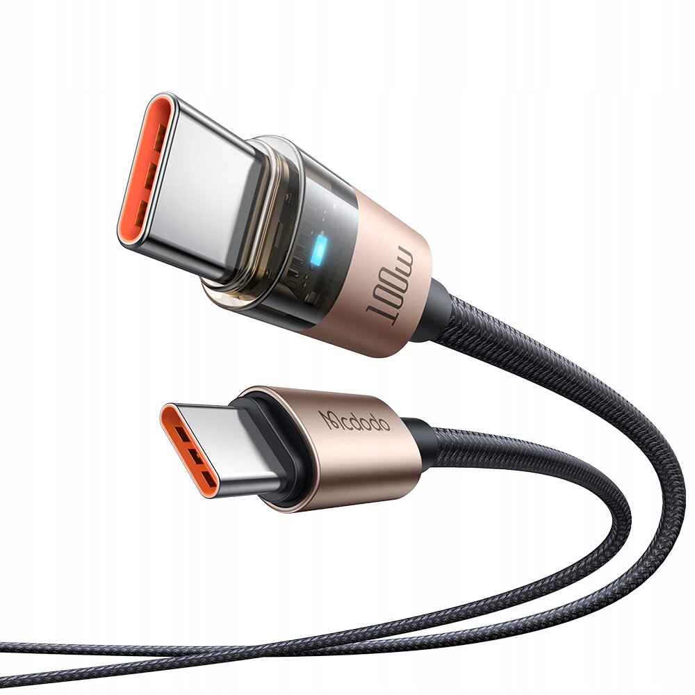 Obraz przedstawia złoty kabel USB-C z dwoma wtyczkami, na których widoczne są napisy \'100W\' i \'Mcdodo\'. Kabel ma plecioną osłonę i niebieski wskaźnik LED na jednej z wtyczek.