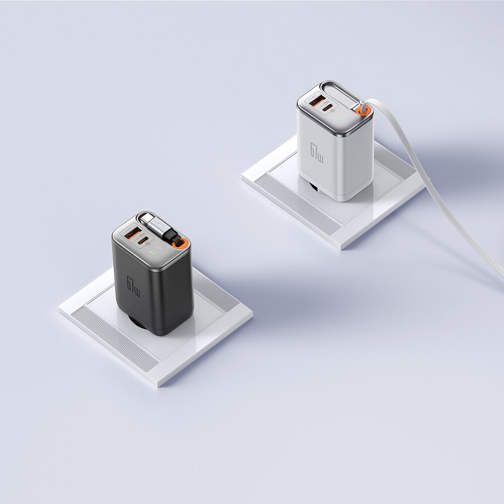 Na obrazie znajdują się dwie ładowarki sieciowe w kolorach czarnym i białym, umieszczone na białych podstawkach. Obie ładowarki mają widoczne porty USB-C i USB-A oraz logo producenta na obudowie.