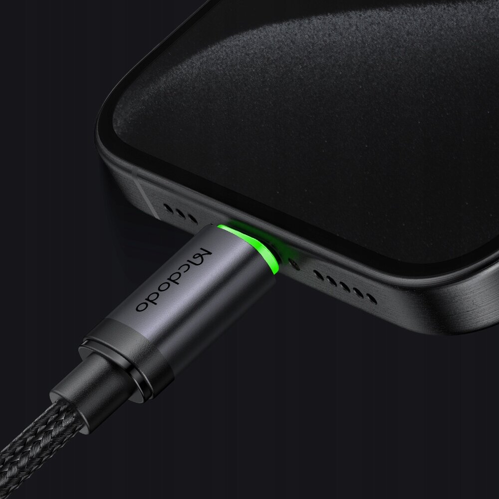Zbliżenie na kabel USB-C marki Mcdodo podłączony do urządzenia, z zielonym podświetleniem wokół wtyczki.