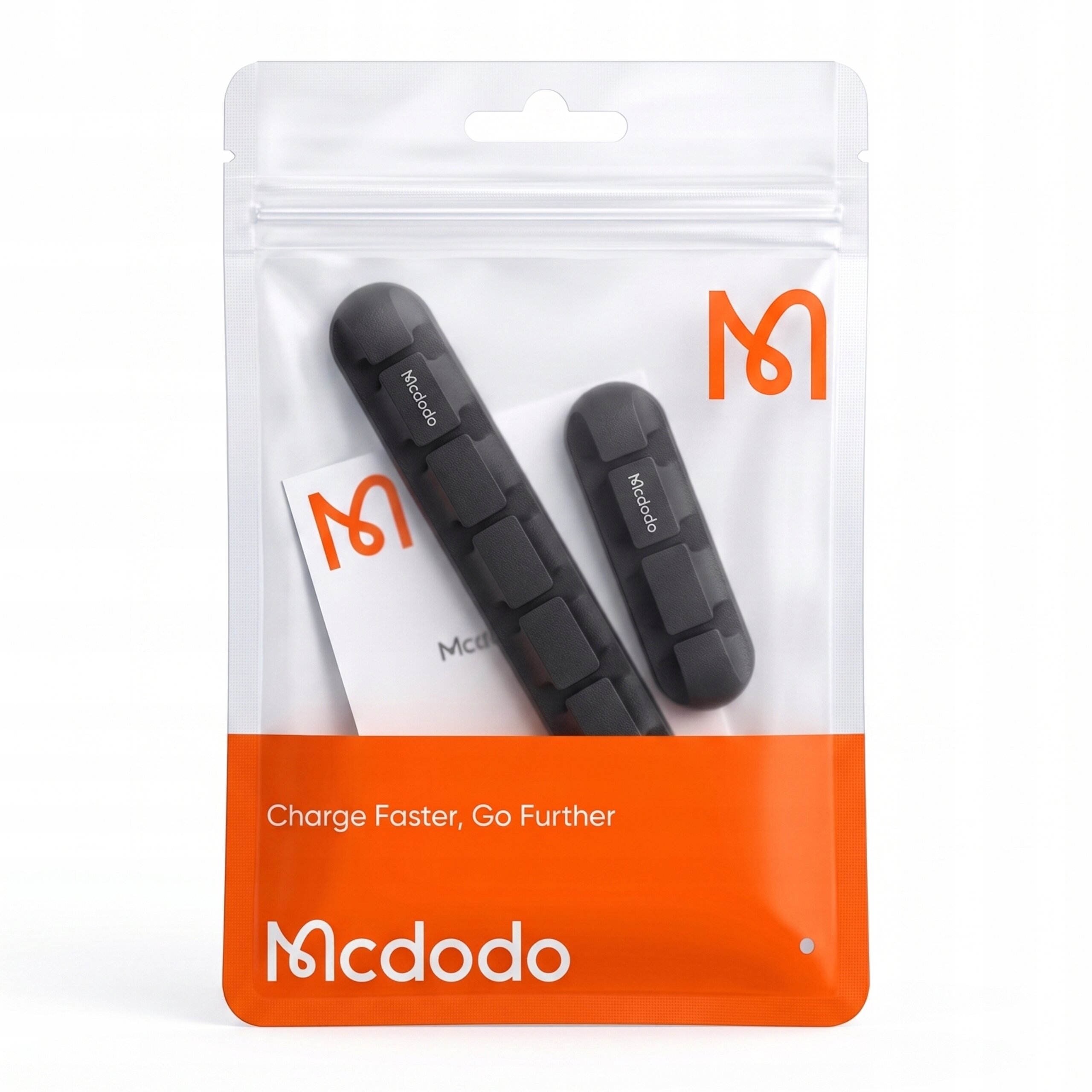 Opakowanie zawiera dwa czarne uchwyty na kable z logo \'Mcdodo\'. Na opakowaniu widnieje napis \'Charge Faster, Go Further\'.