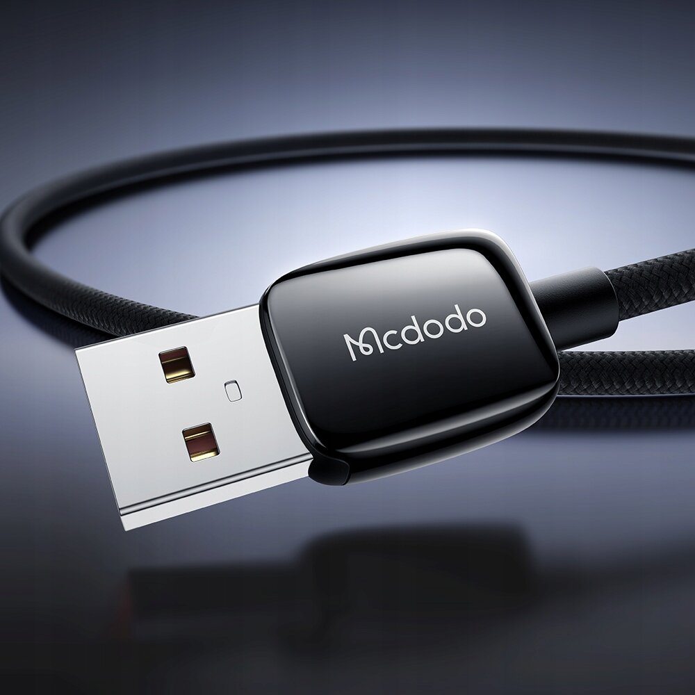 Zdjęcie przedstawia czarny kabel USB-A z logo \'Mcdodo\' na wtyczce, umieszczony na ciemnym tle.