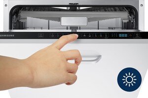 Samsung Prosty i intuicyjny panel sterowania. Czytelny wyświetlacz LED Osoba dotyka panelu sterowania zmywarki z widocznymi przyciskami i wyświetlaczem. Na dole znajduje się symbol słońca na niebieskim tle.