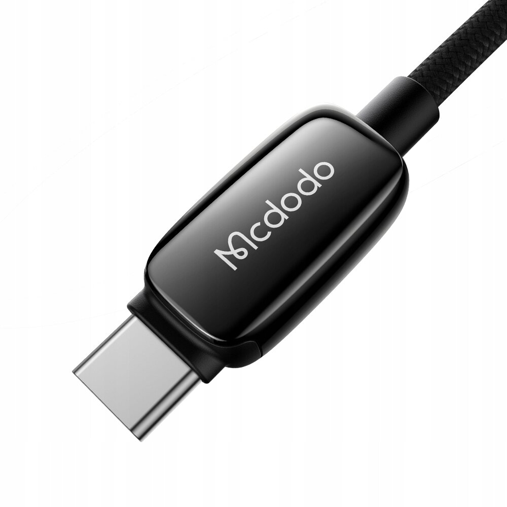 Na obrazie widoczny jest czarny kabel USB-C z logo \'Mcdodo\' na obudowie złącza. Kabel ma plecioną strukturę.