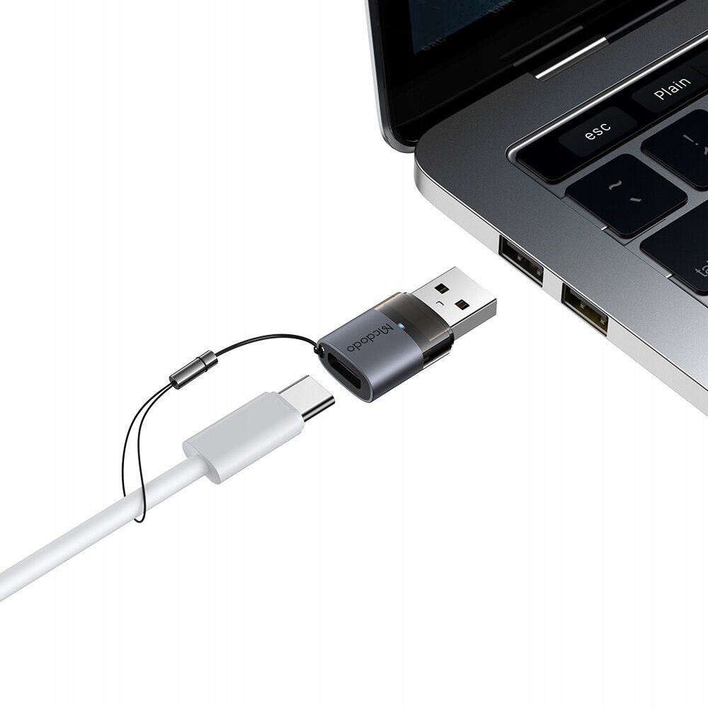 Na obrazie widać adapter USB-A do USB-C podłączony do laptopa. Na adapterze znajduje się napis \'Mcdodo\'.