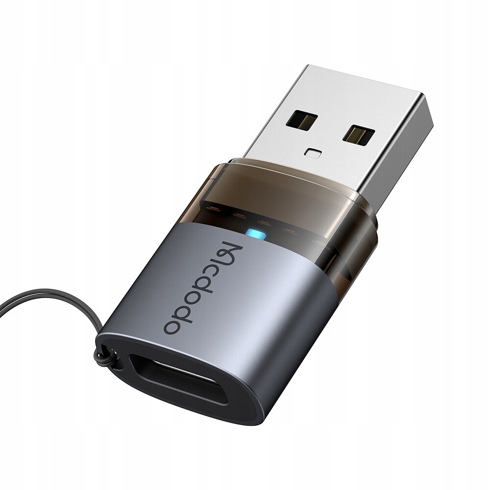 Na obrazie widoczny jest adapter USB z napisem \'Mcdodo\' oraz niebieskim wskaźnikiem LED. Adapter ma metaliczną obudowę i złącze USB-A oraz USB-C.