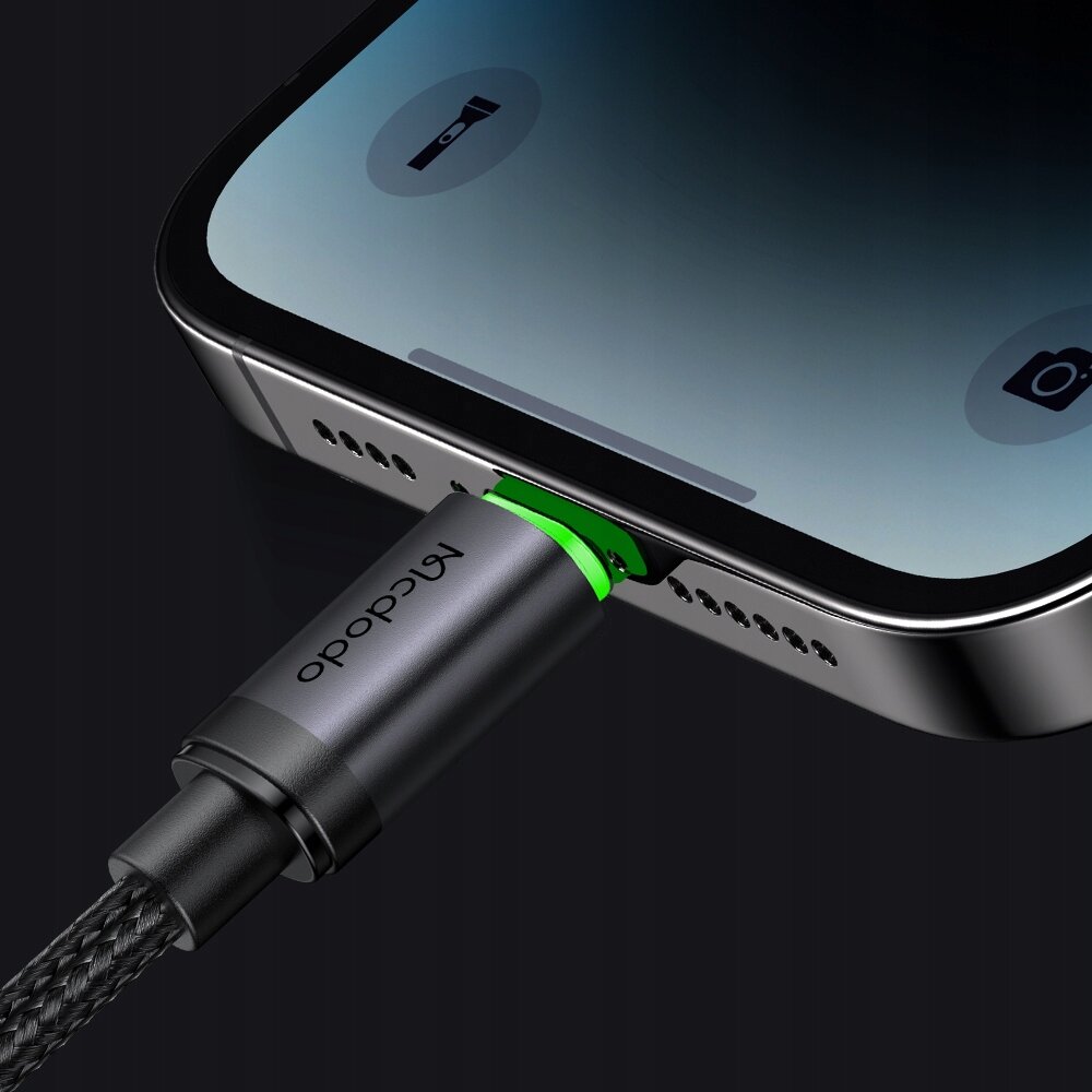 Zbliżenie na kabel USB z logo \'Mcdodo\' podłączony do portu smartfona. Wtyczka kabla jest podświetlona na zielono.