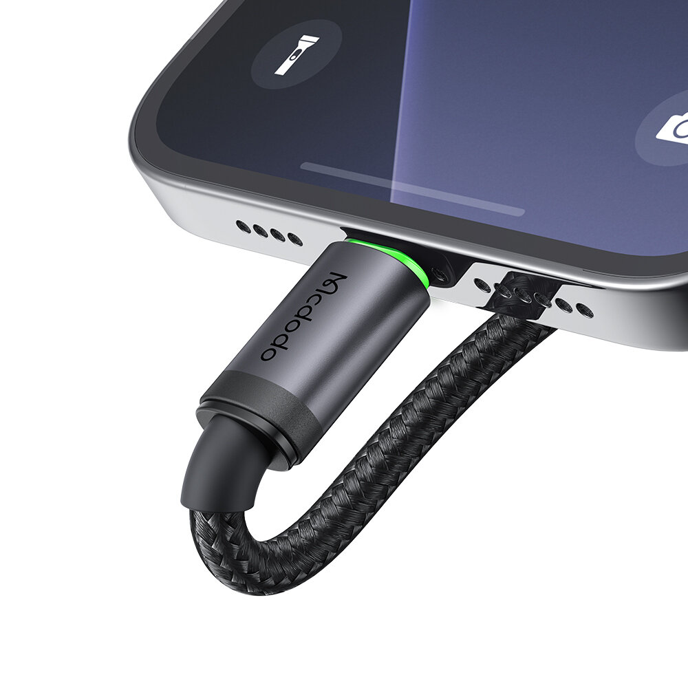 Zbliżenie na kabel USB Lightning podłączony do smartfona, z widocznym napisem \'Mcdodo\' na obudowie wtyczki.