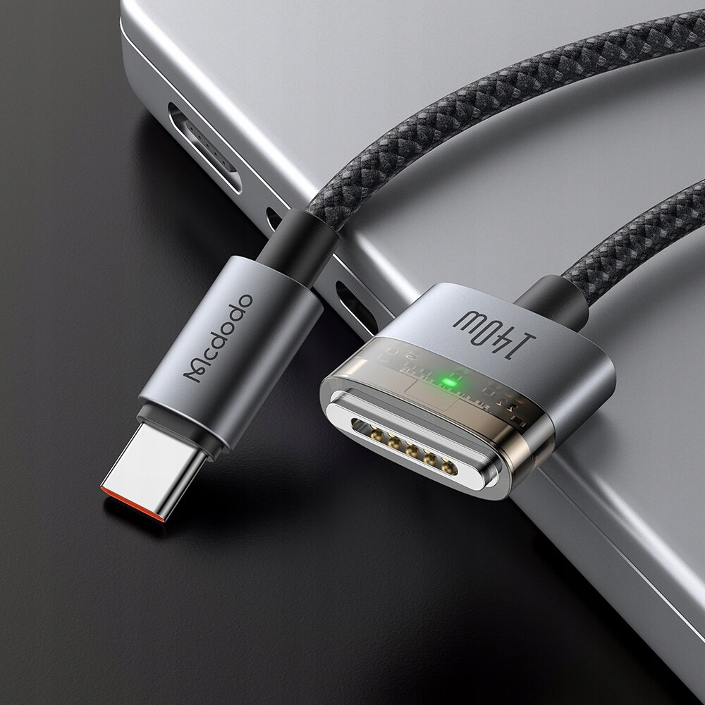 Zdjęcie przedstawia kabel zasilający z końcówką USB-C i Magsafe 3, z widocznym logo \'Mcdodo\' na jednej z wtyczek oraz zielonym wskaźnikiem świetlnym na drugiej końcówce.
