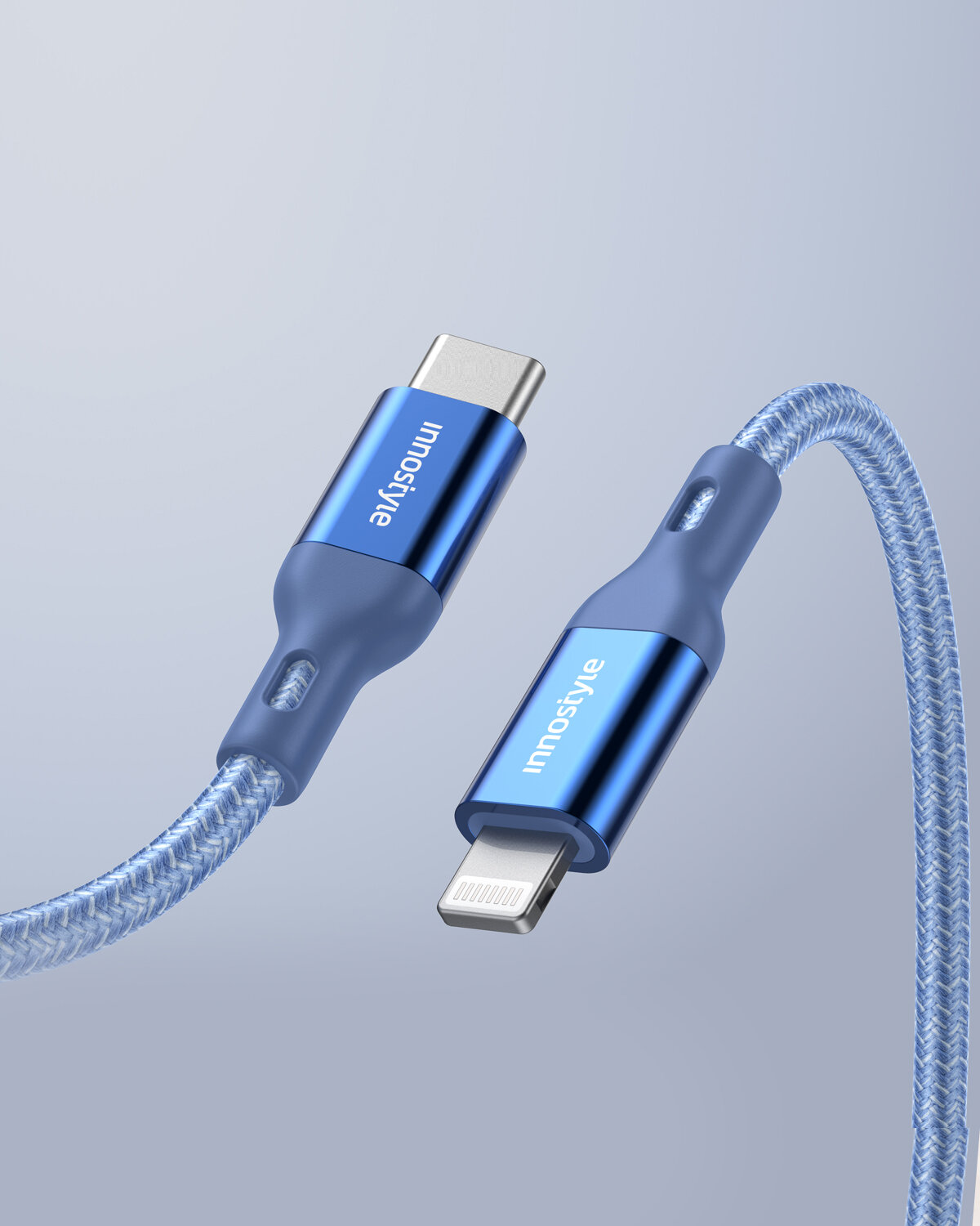 Na obrazie widoczny jest niebieski kabel USB-C do Lightning z plecionym oplotem i metalowymi końcówkami, na których znajduje się napis \'Innostyle\'.