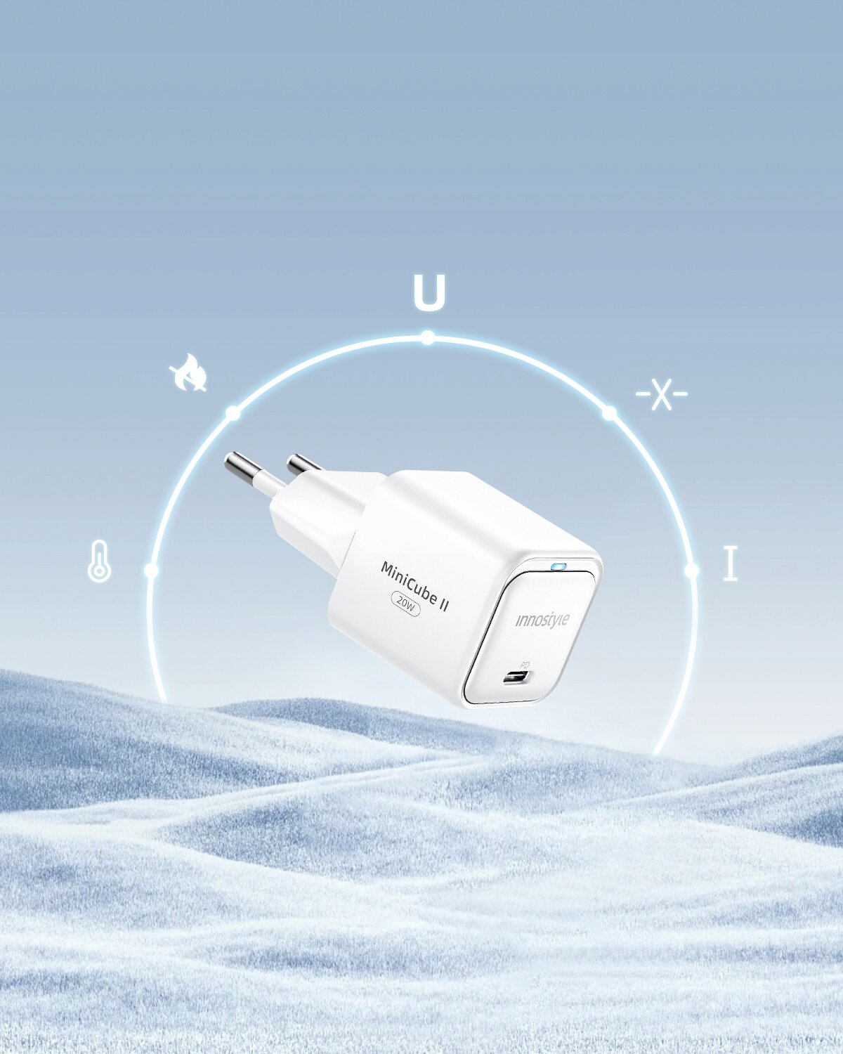 Biała ładowarka USB-C z napisem \'MiniCube II 33W\' i \'innostyle\' unosi się nad zimowym krajobrazem. W tle widoczne są symbole i litery na niebieskim tle.
