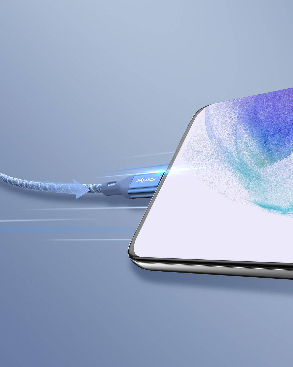 Na zdjęciu widoczny jest kabel USB-C z niebieskim oplotem, podłączony do urządzenia z ekranem, na którym widać abstrakcyjny wzór. Na wtyczce kabla znajduje się napis \'Innostyle\'.