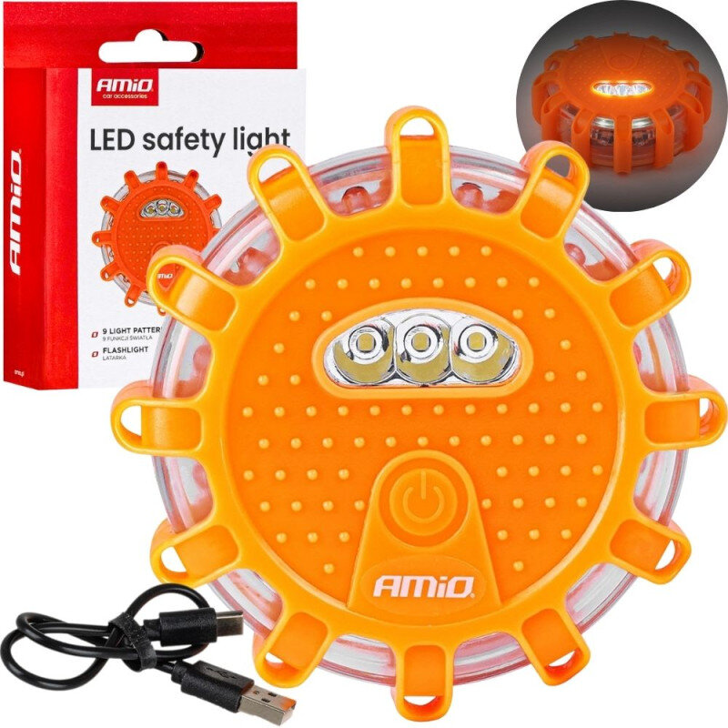 Na obrazie widoczna jest pomarańczowa lampa ostrzegawcza z trzema diodami LED i przyciskiem zasilania, obok której znajduje się kabel USB. W tle znajduje się opakowanie z napisem \'AMiO LED safety light\'.