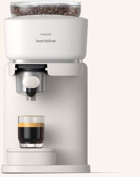 Ekspres do kawy w jasnym kolorze z widocznym logo \'PHILIPS baristina\'. Na ekspresie znajduje się szklanka z kawą, a na górze pojemnik z ziarnami kawy.