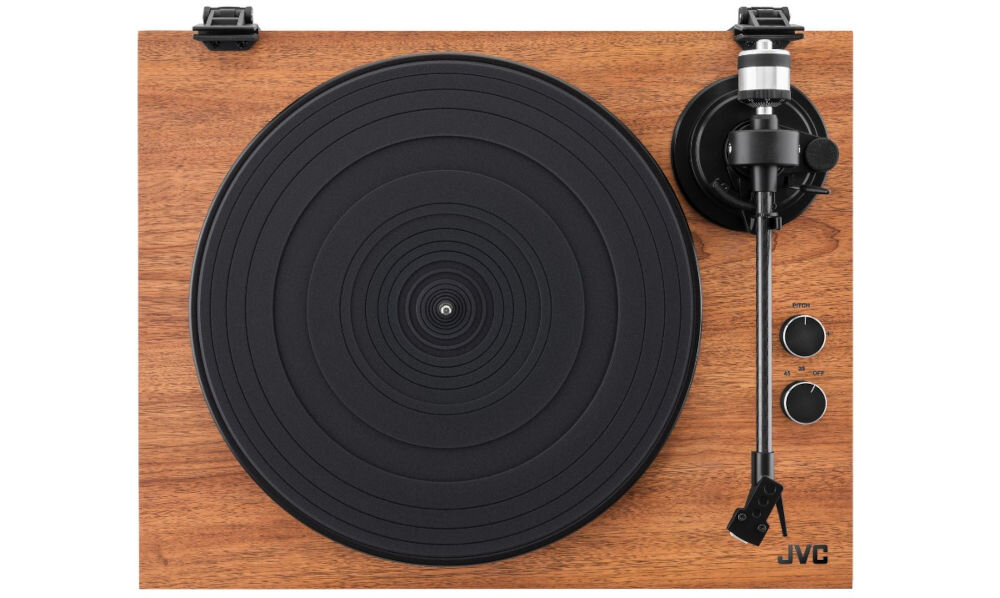 Gramofon z drewnianą obudową, czarnym talerzem i ramieniem z igłą. Widoczne logo JVC oraz dwa pokrętła na panelu.