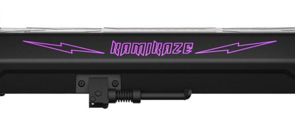 Czarny element hulajnogi z widocznym logo \'KAMIKAZE\' w kolorze fioletowym oraz dwoma fioletowymi błyskawicami po bokach.