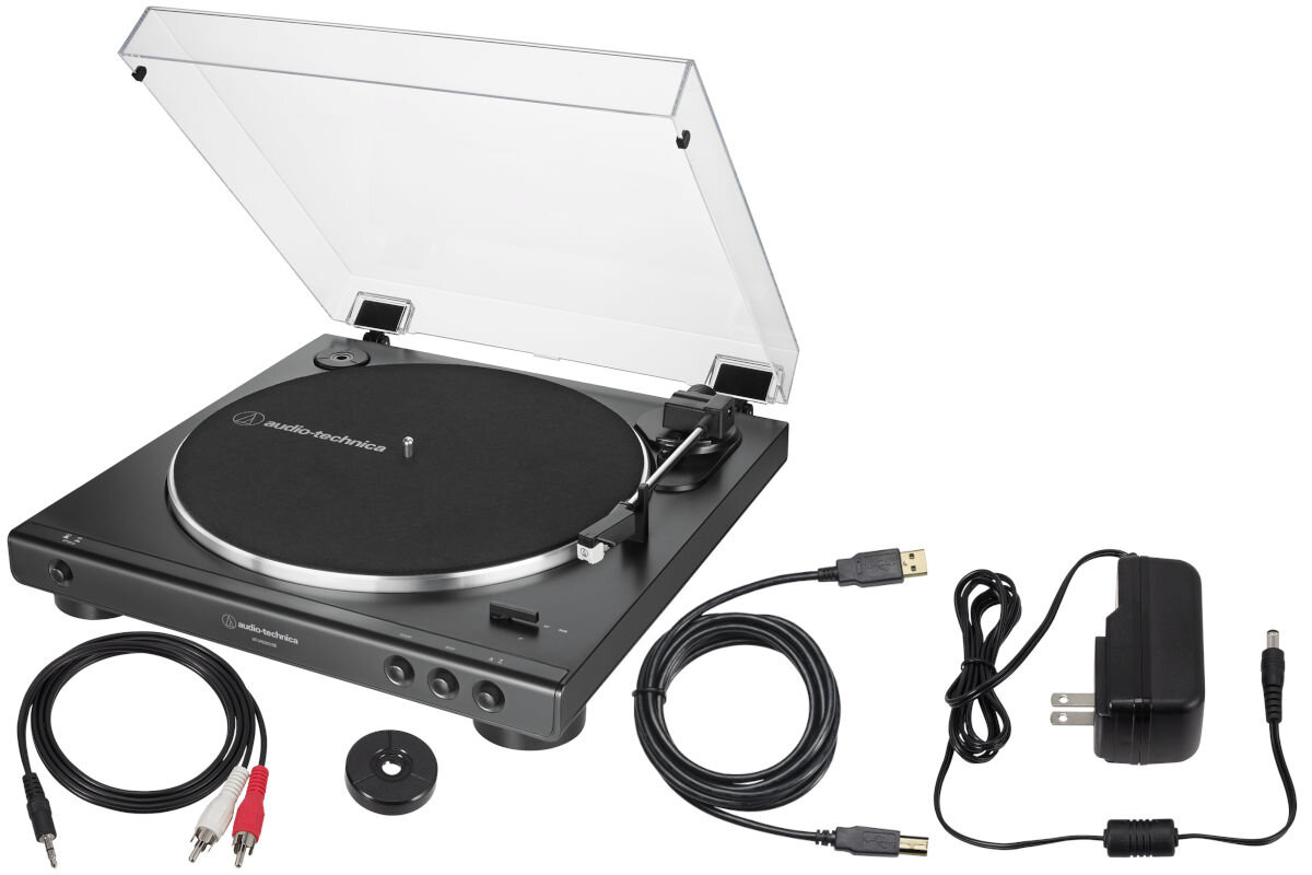 Na obrazie znajduje się czarny gramofon z przezroczystą pokrywą, obok którego leżą różne kable i zasilacz. Na gramofonie widoczne jest logo \'audio-technica\'.