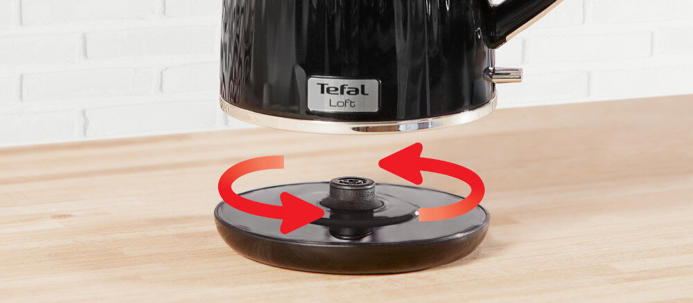 Czarny czajnik z logo \'Tefal Loft\' unosi się nad okrągłą podstawą, wokół której widoczne są czerwone strzałki wskazujące możliwość obrotu.