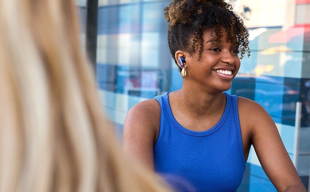 Słuchawki douszne JBL Live Flex 4 etui Smart Charging Case ekran dotykowy sterowanie muzyką ANC, osoba z założonymi słuchawkami,