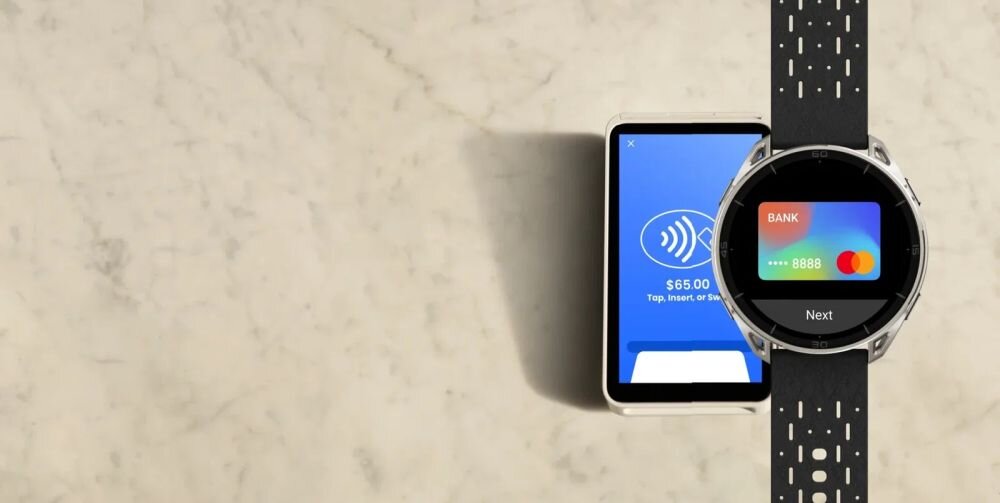 Na marmurowym tle znajduje się smartwatch z wyświetlaczem pokazującym kartę płatniczą oraz telefon z ekranem płatności zbliżeniowej z kwotą .00.