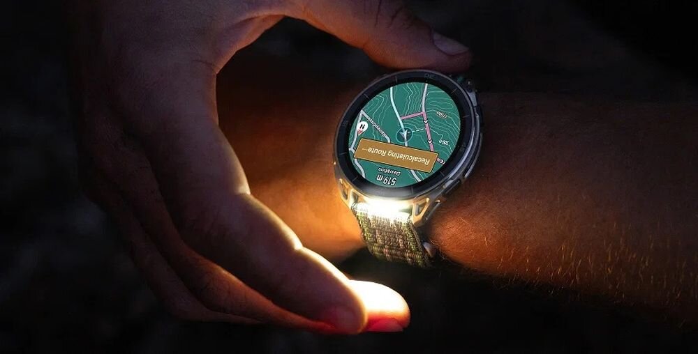 Osoba nosi smartwatch z wyświetlaczem pokazującym mapę i trasę. Na ekranie widoczny jest tekst: \'media expert\'.