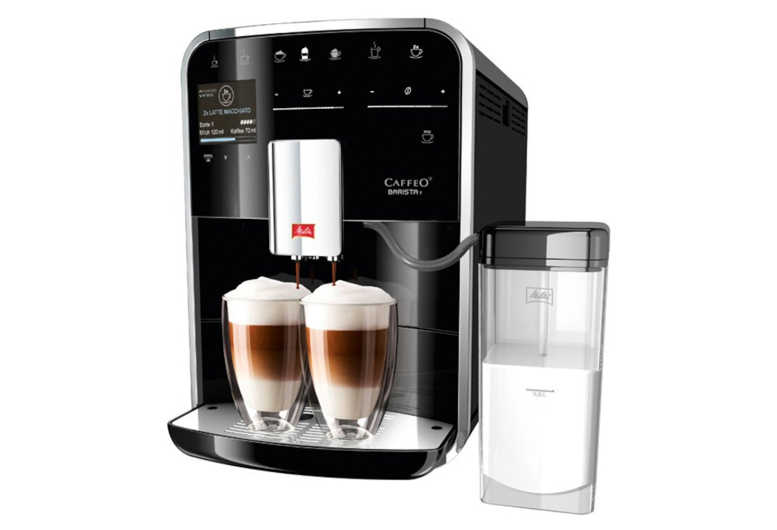 Czarny ekspres do kawy z wyświetlaczem i przyciskami dotykowymi, przygotowujący dwa latte macchiato w szklankach. Obok znajduje się przezroczysty pojemnik na mleko z logo MELITTA.