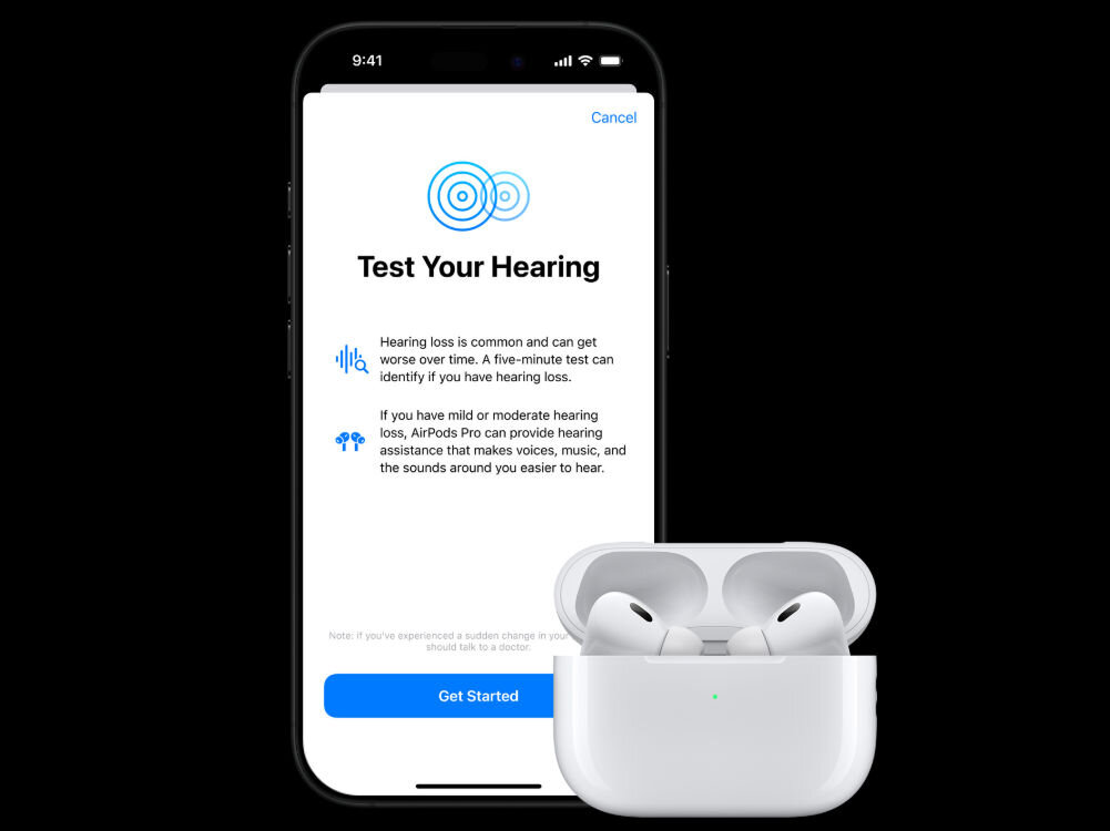 Na obrazie widoczny jest ekran smartfona z aplikacją \'Test Your Hearing\' oraz białe słuchawki dokanałowe w etui. Tekst na ekranie informuje o możliwości przeprowadzenia testu słuchu i oferuje pomoc w przypadku łagodnej lub umiarkowanej utraty słuchu.