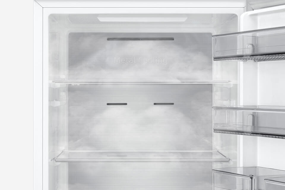 Wnętrze lodówki z półkami i szufladami, na tylnej ściance widoczny napis \'Metal Cooling\'.