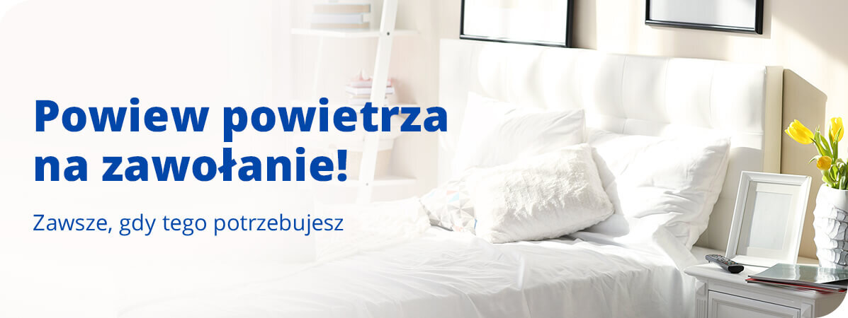 Na obrazie widoczna jest sypialnia z białym łóżkiem i stolikiem nocnym, na którym stoi wazon z żółtymi kwiatami. Tekst na obrazie: \'Powiew powietrza na zawołanie! Zawsze, gdy tego potrzebujesz\'.