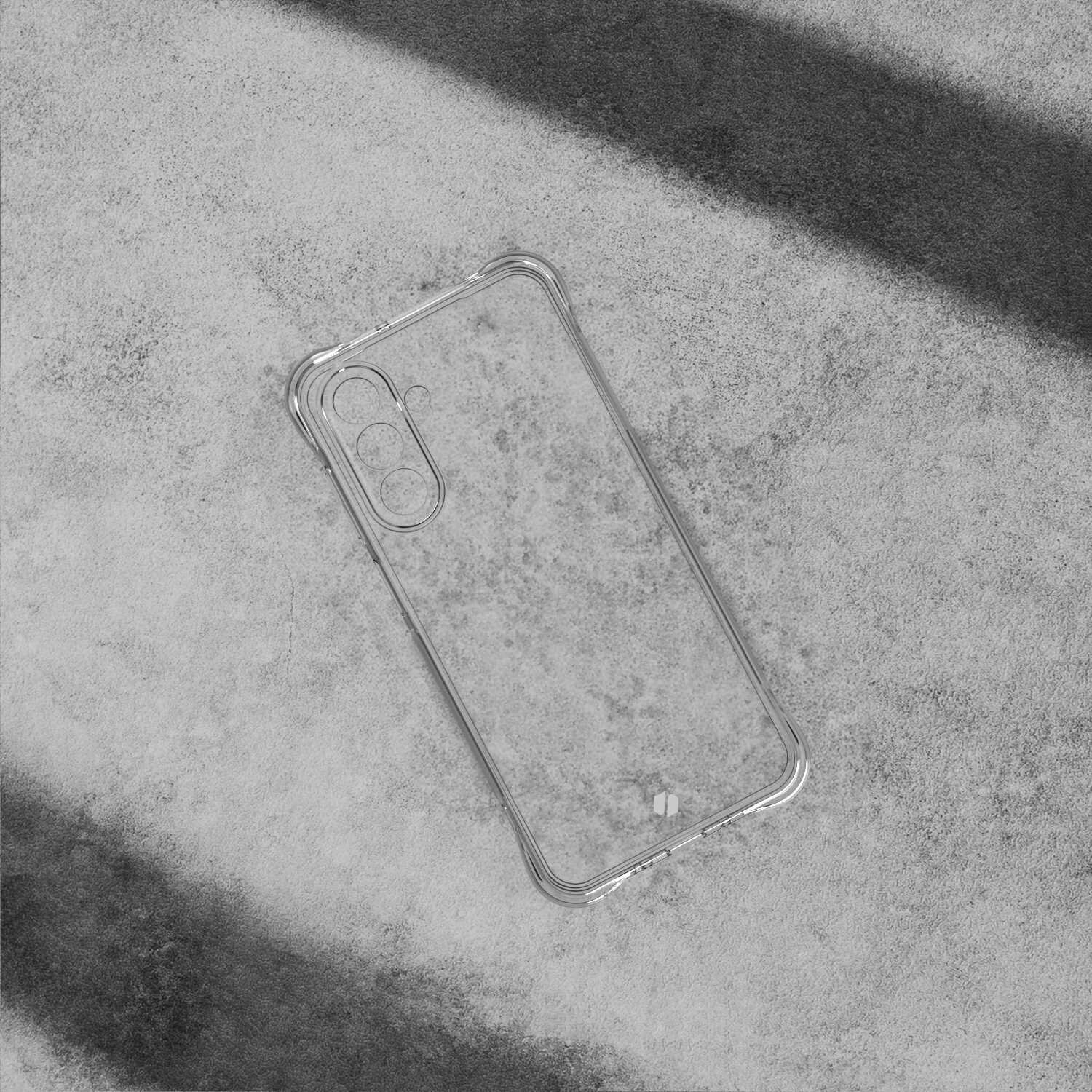 Przezroczyste silikonowe etui na telefon z widocznymi wzmocnieniami na rogach, leży na betonowej powierzchni. Etui ma wycięcia na aparat i przyciski.