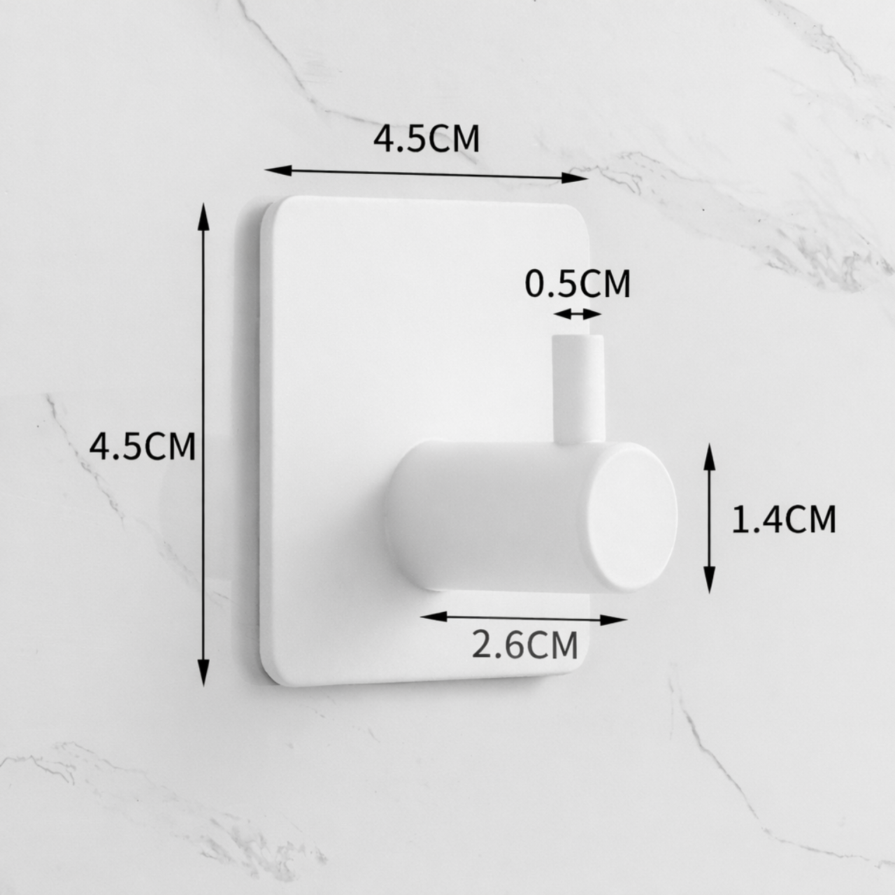 Na obrazie widoczny jest biały, samoprzylepny haczyk łazienkowy o wymiarach 4.5CM x 4.5CM. Dodatkowe wymiary to 0.5CM, 1.4CM i 2.6CM, przedstawione na tle jasnej ściany.