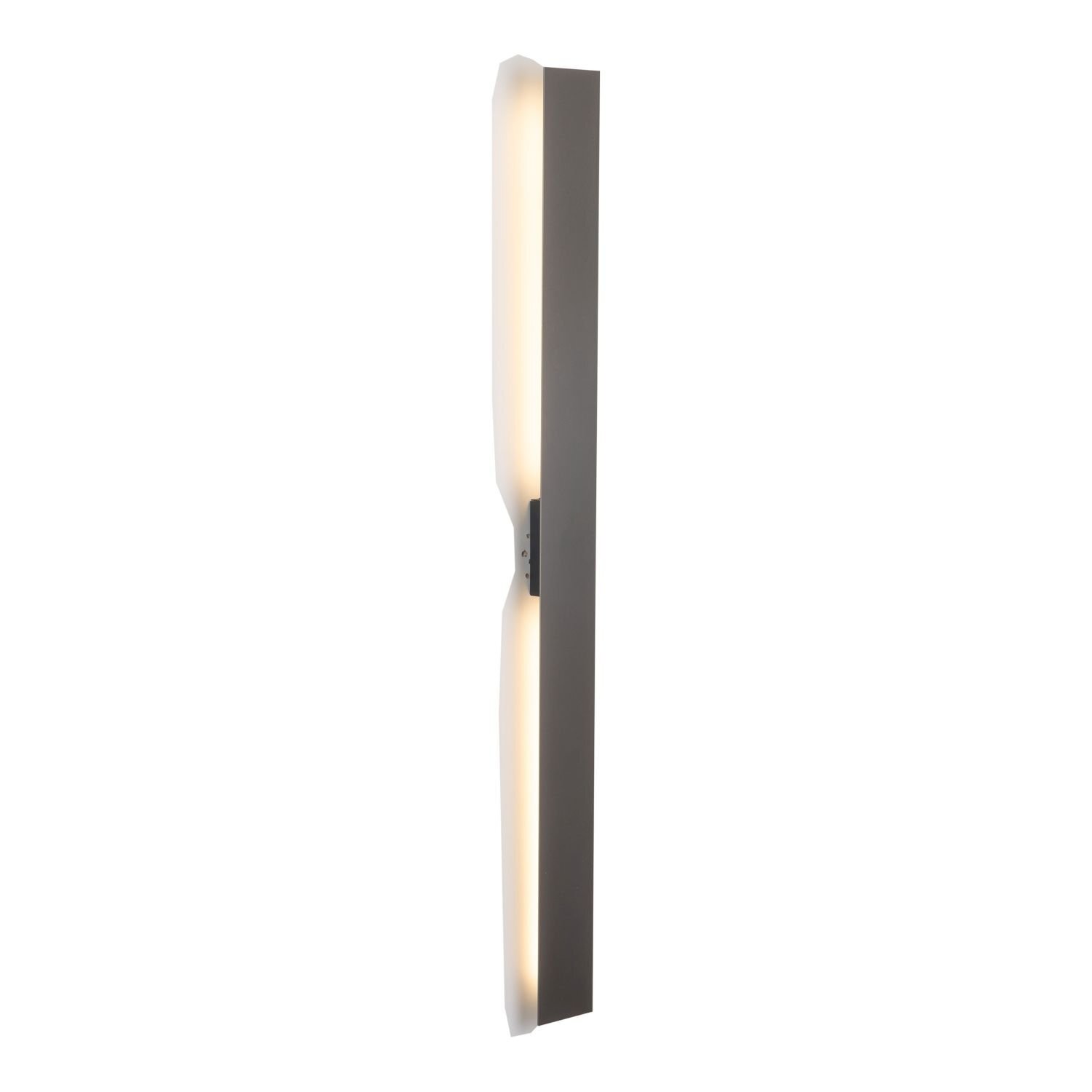 Na obrazie widoczny jest nowoczesny kinkiet LED w kolorze brązowym, o smukłej, pionowej formie z delikatnym podświetleniem po bokach. Lampa ma minimalistyczny design i jest przymocowana do ściany.